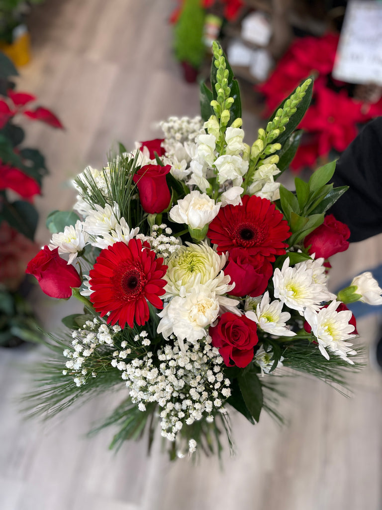 Bouquet of red and white flowers with Christmas greenery 