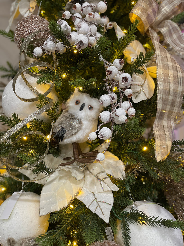 Decorative Christmas tree with white owls, berries, and ribbons.