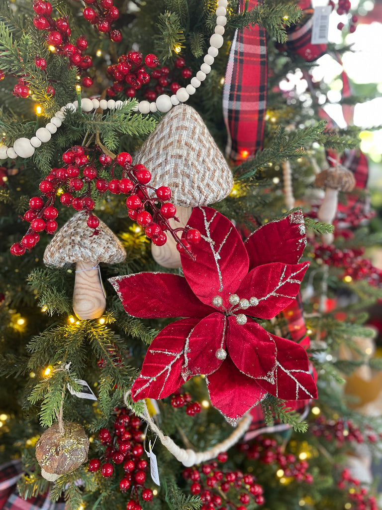 Decorative Christmas tree with red poinsettia, mushrooms, and berries.